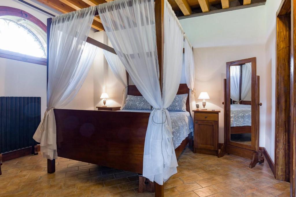 a bedroom with a canopy bed with curtains at Medieval Relais - Top location in Montagnana