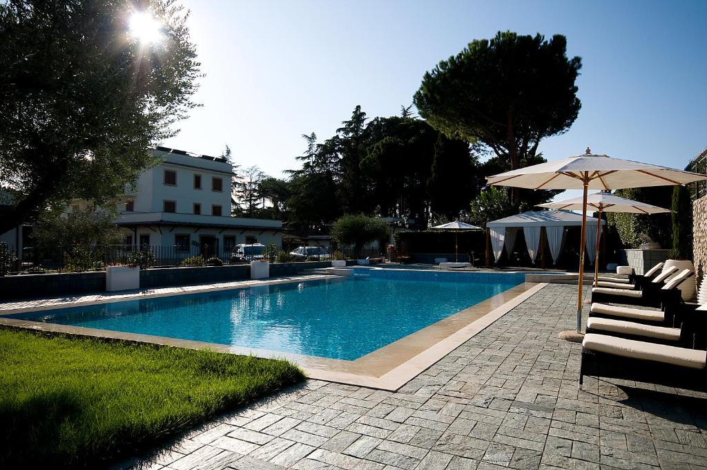 piscina con ombrellone e alcune sedie di Hotel Castle a Roma