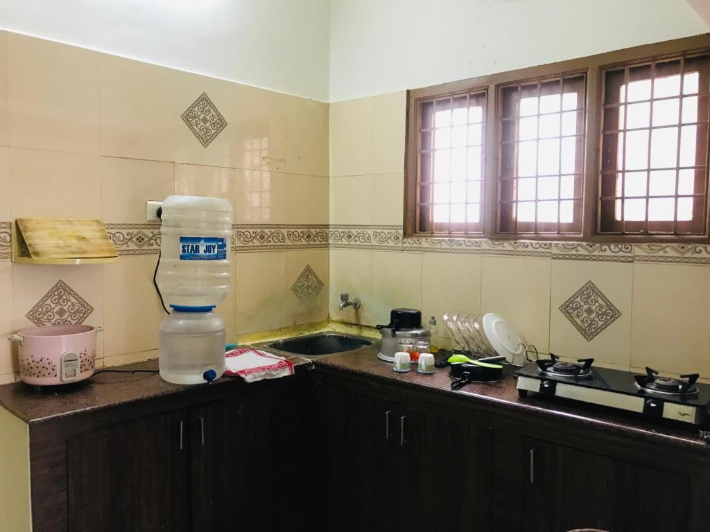 a kitchen with a bottle of water on a counter at Bethel house in Chennai