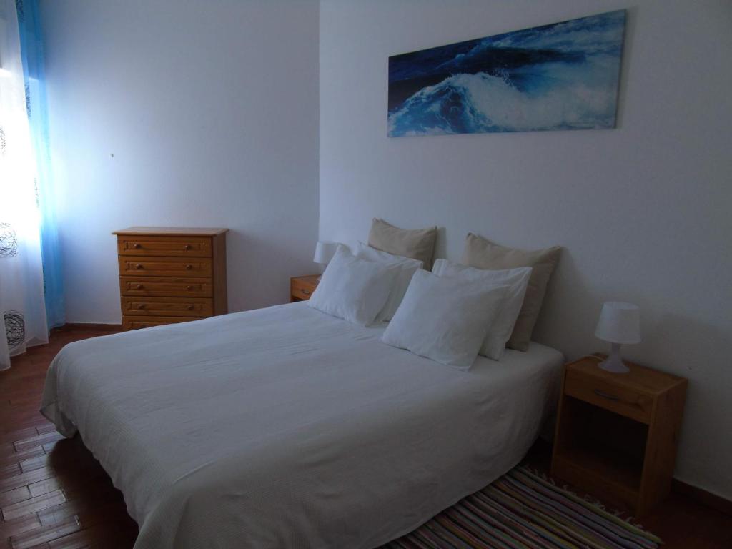 a bedroom with a bed with white sheets and pillows at Cantinho Das Estrelas, Luz Lagos in Luz