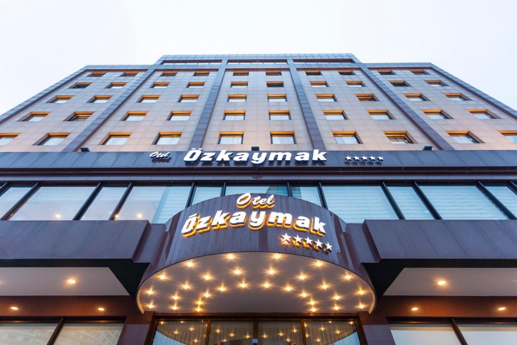 コンヤにあるOzkaymak Konya Hotelの看板が上がる高層ビル