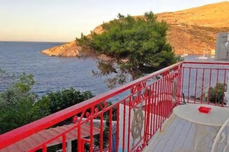 a red balcony with a view of the ocean at Tramontana in Hydra