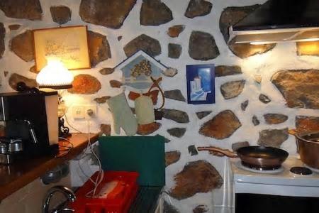 a stone wall with a stove in a kitchen at Tramontana in Hydra
