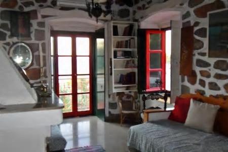 a living room with a couch and two windows at Tramontana in Hydra