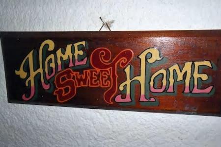 a sign on a wall with the words share a sweet home at Tramontana in Hydra