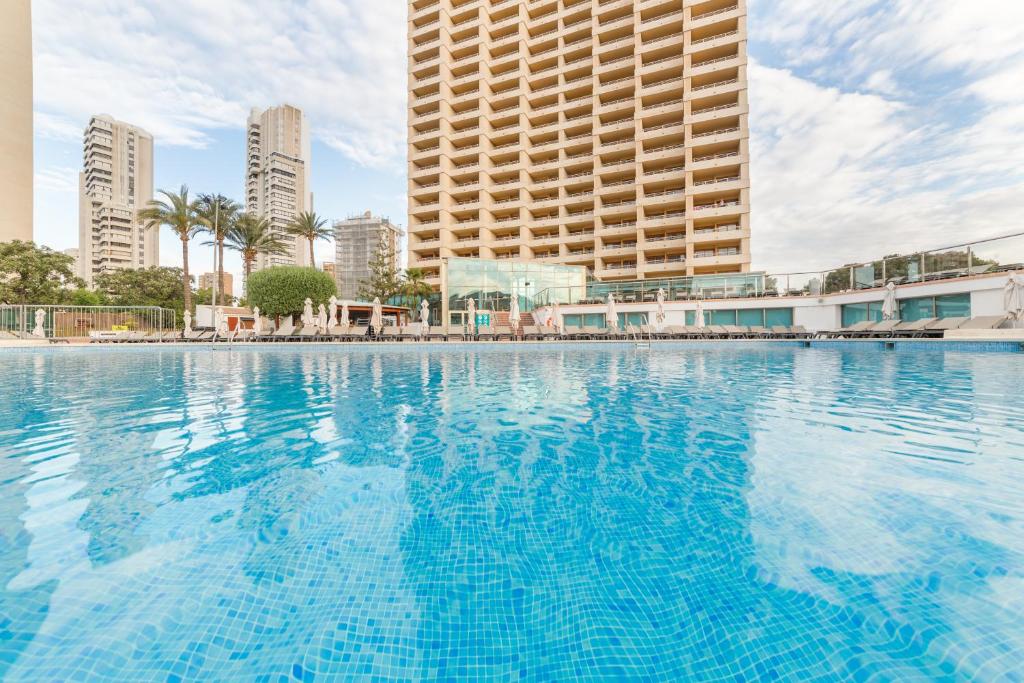 ein großes Schwimmbad in einer Stadt mit hohen Gebäuden in der Unterkunft Sandos Benidorm Suites in Benidorm