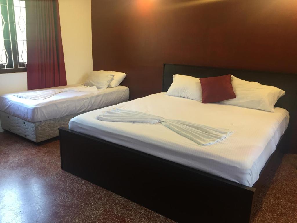 two beds in a hotel room with towels on them at Nallur Residence in Jaffna
