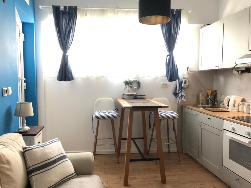 a kitchen with a table and chairs in a room at Omiš Sweet Navy apartment in Omiš
