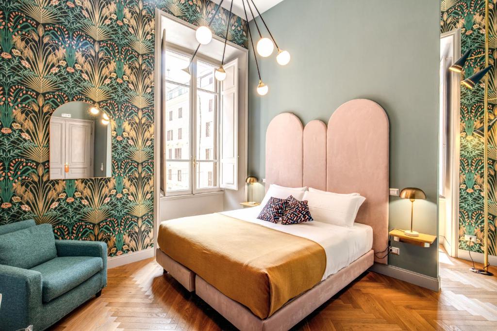 een slaapkamer met een bed en een blauwe stoel bij Glance in Rome in Rome