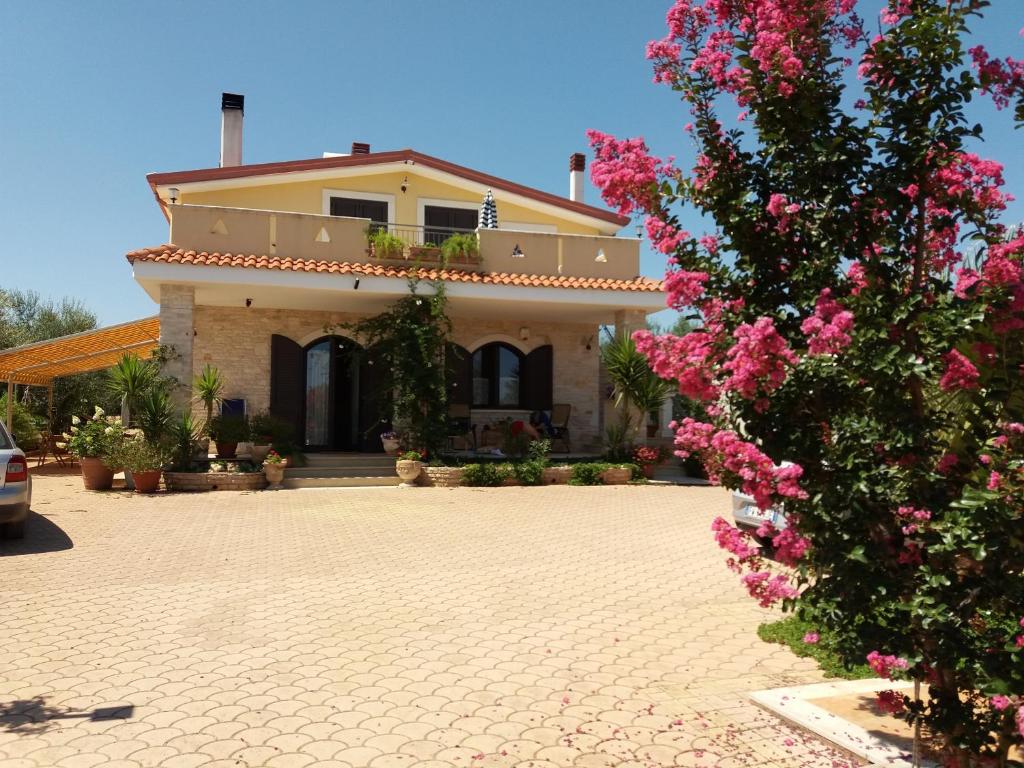 una casa con fiori rosa di fronte di Villa Calendula a Corato