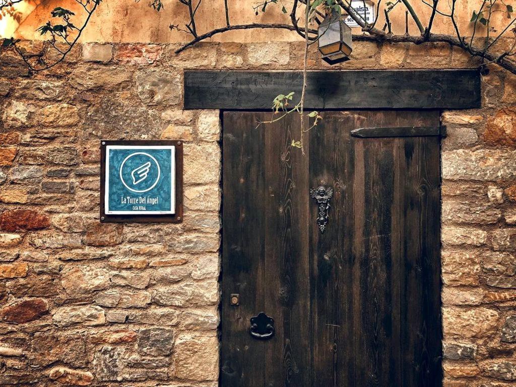 a wooden door on the side of a stone building at La Torre Del Angel Casa Rural in Mirambel