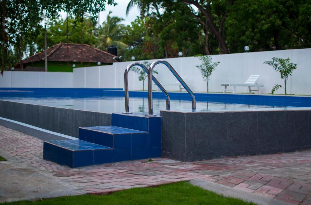 a swimming pool with stairs in the middle at MRD Beach Hotel in Trincomalee