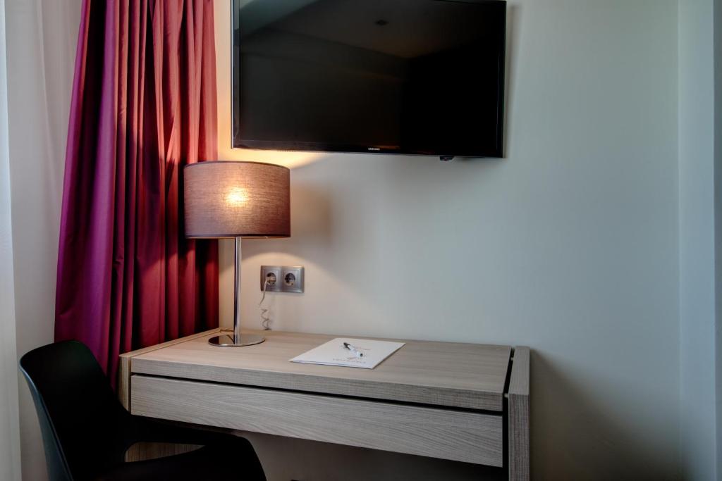 Uma televisão e/ou sistema de entretenimento em VIP Inn Berna Hotel