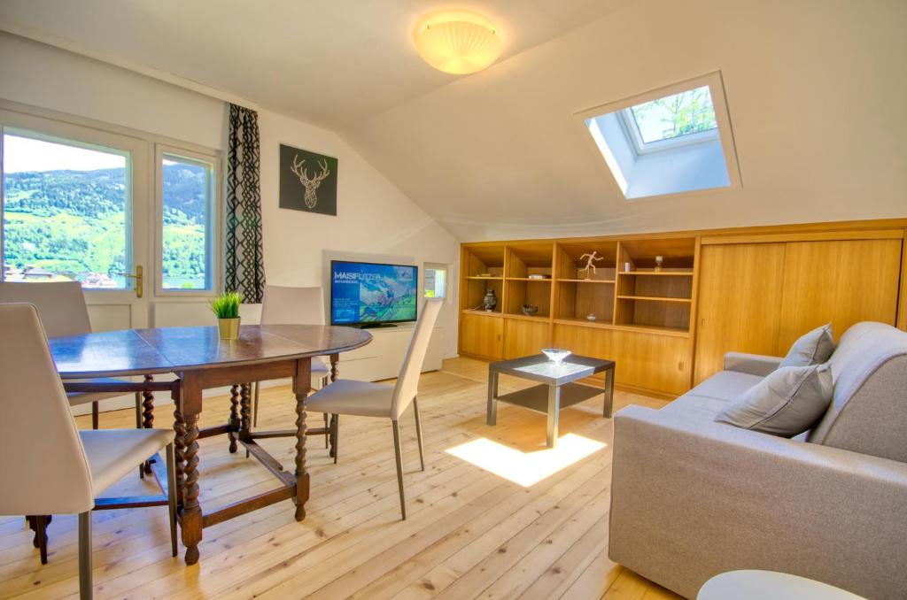 a living room with a table and a couch at Mozart Top 3 - by Alpen Apartments in Zell am See