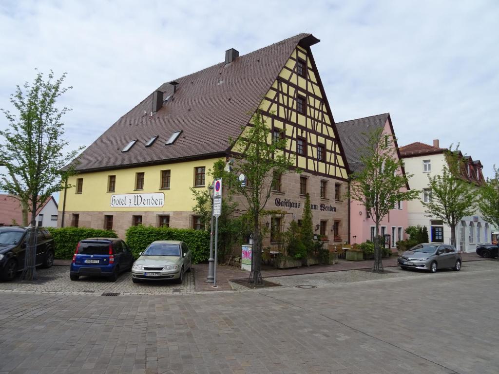 a large yellow building with a black and white roof at Hotel,Gasthaus zum Wenden in Wendelstein