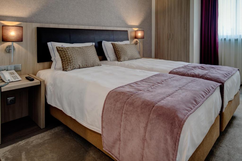 um quarto de hotel com uma cama grande e um telefone em VIP Inn Berna Hotel em Lisboa