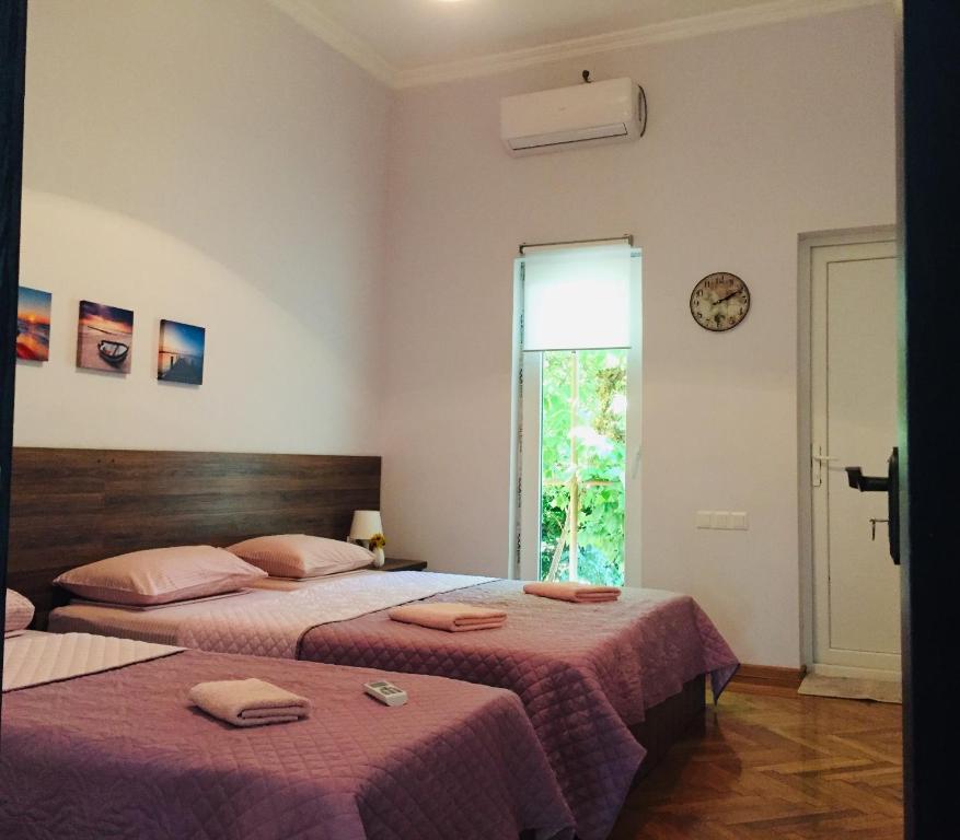 1 dormitorio con 2 camas y ventana en Guest House Hello en Kutaisi