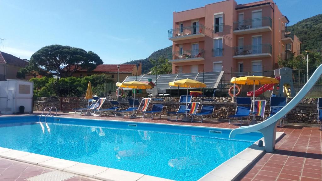 a swimming pool with a slide in front of a hotel at Residence Mizar in Pietra Ligure