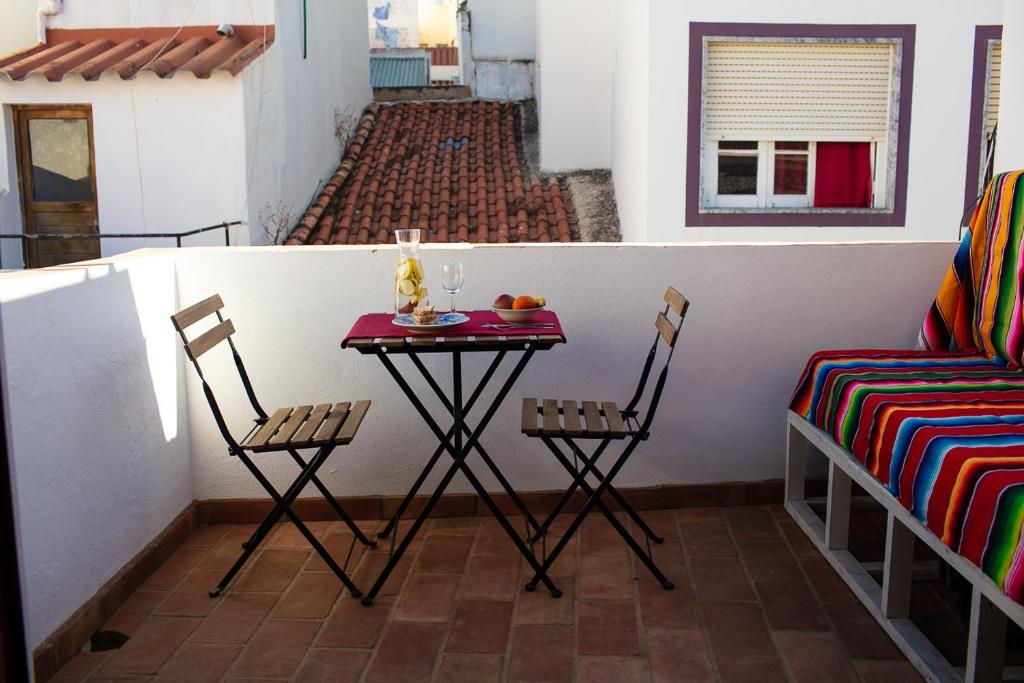 una mesa pequeña y sillas en un balcón con mesa en Typical fishing village in historic center I, en Portimão