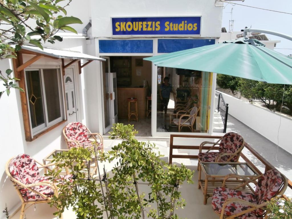 a group of chairs and an umbrella on a patio at Skoufezis Studios in Kardamaina