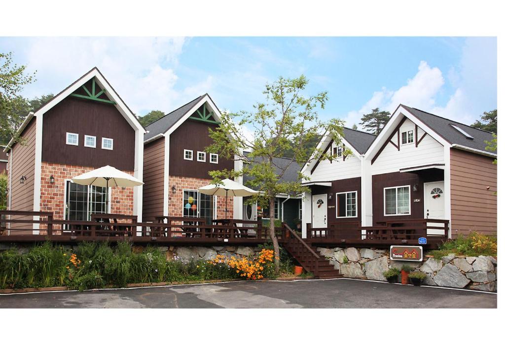 a row of houses with tables in front of them at Soop and Soop Pension in Pyeongchang