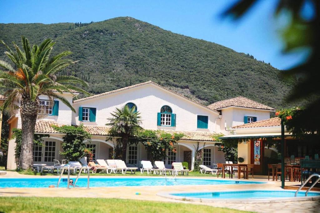 a house with a swimming pool in front of a mountain at Valentino Corfu in Ýpsos