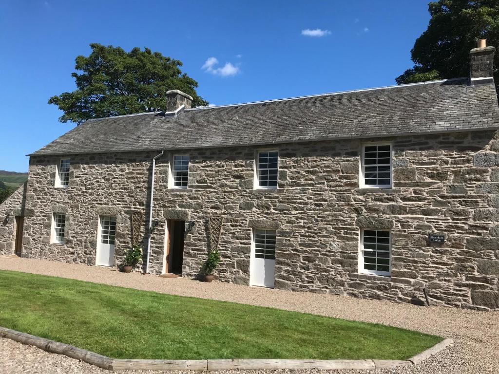 an old stone building with grass in front of it at Brandoch Lodge in Logierait