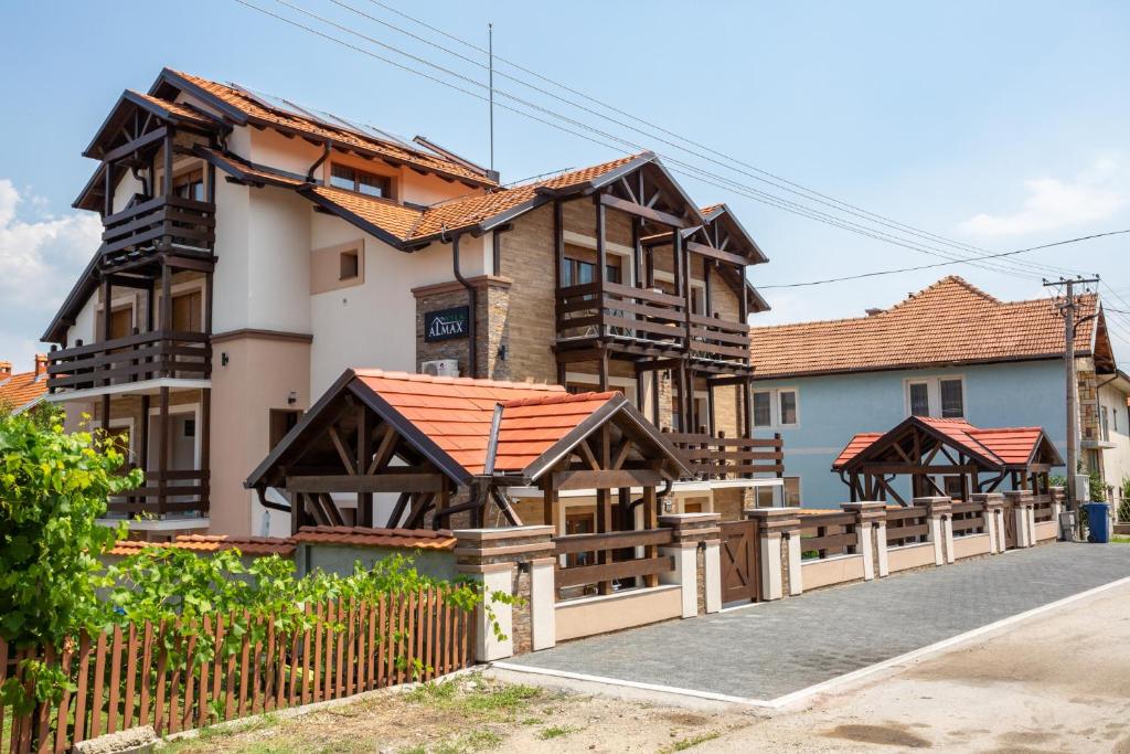 a house with a wooden fence in front of it at Vila Almax in Soko Banja