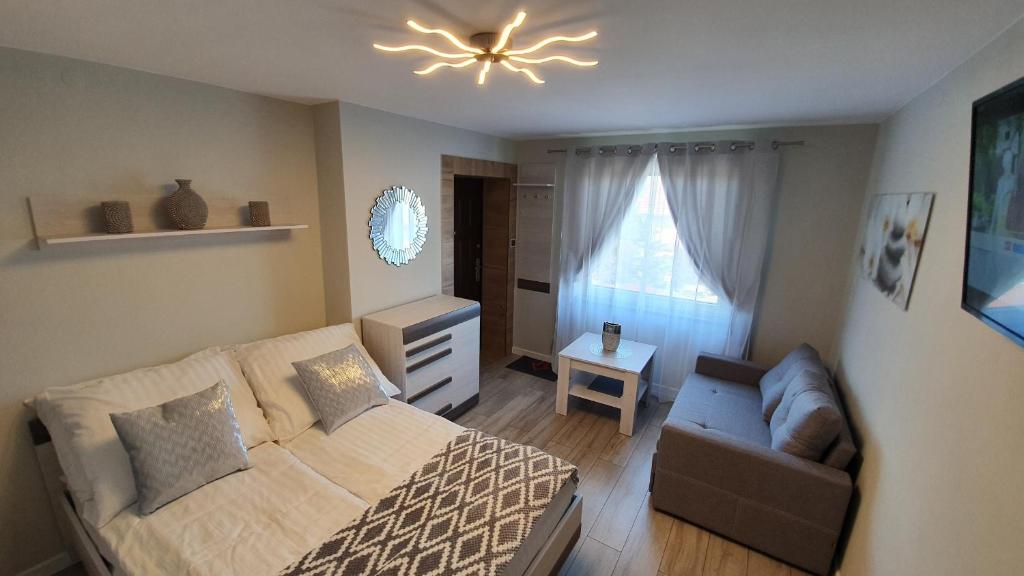 a bedroom with a bed and a couch and a ceiling fan at Pokoje Gościnne Mączyński in Polanica-Zdrój