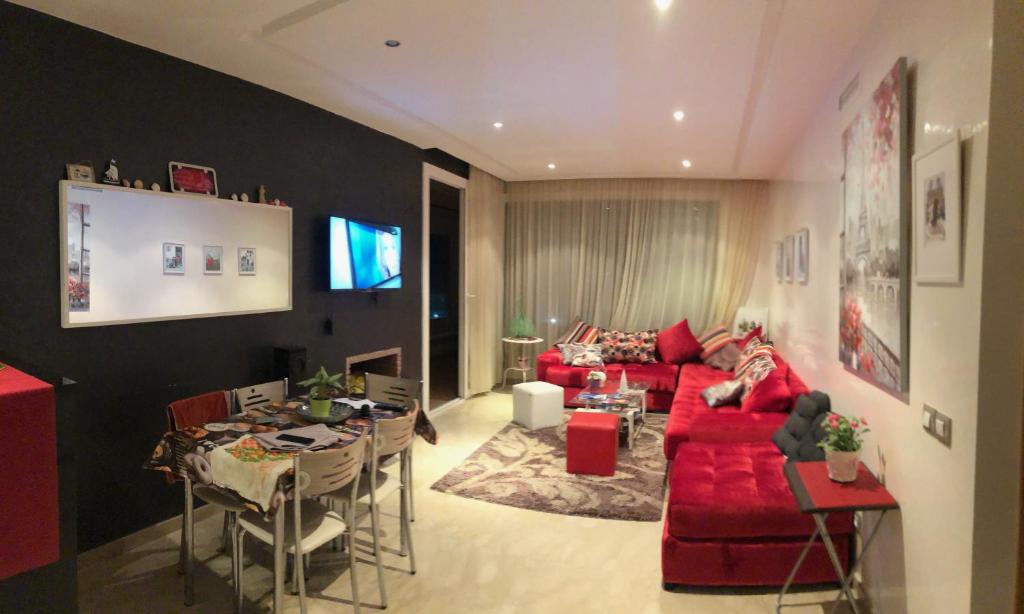 un soggiorno con divano rosso e tavolo di Cozy & Luxurious apartment with seaview a Bouznika