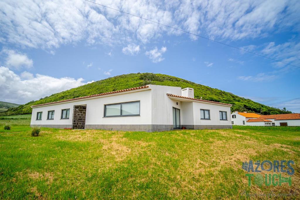 una casa con una colina sobre ella en Casa da Barra, en Santa Cruz da Graciosa