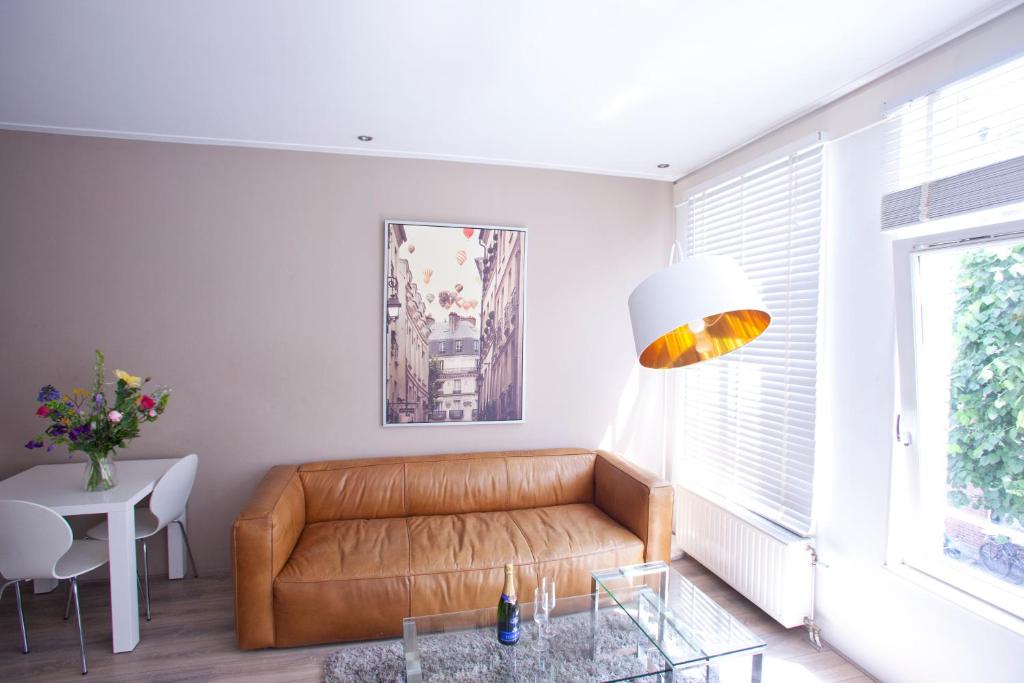 a living room with a leather couch and a table at Amsterdam city center apartments in Amsterdam