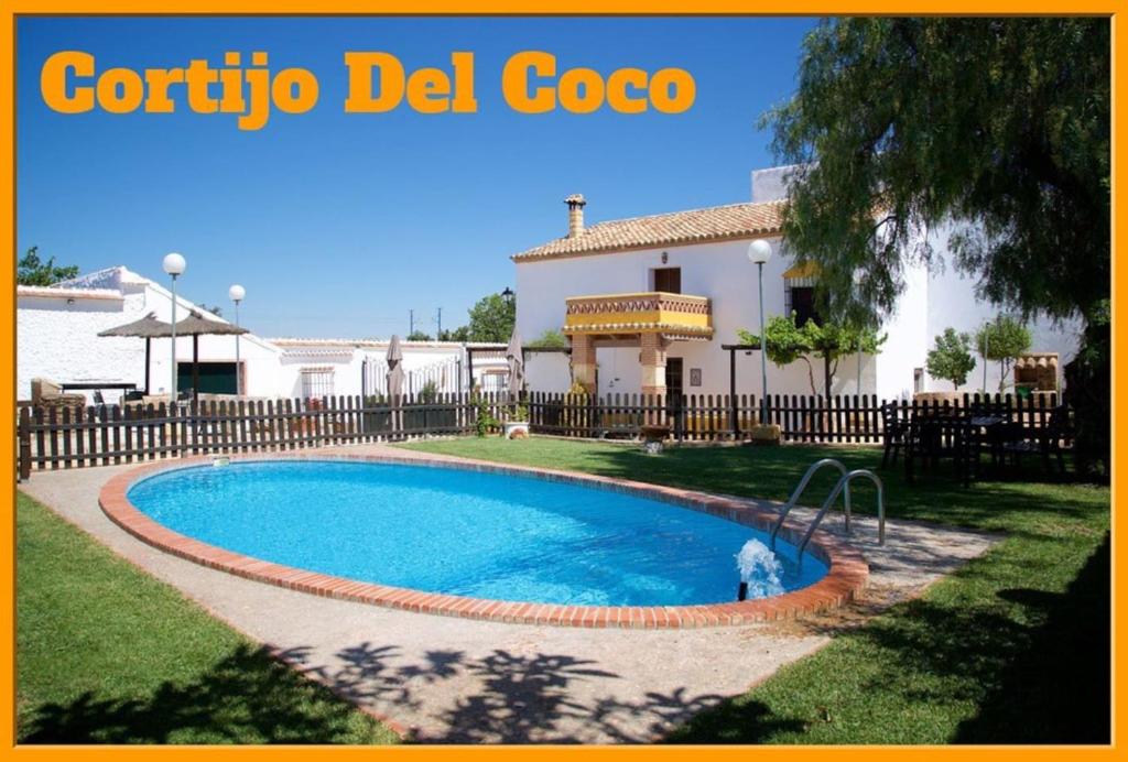 a swimming pool in the yard of a house at Cortijo del Coco in Fuente de Piedra