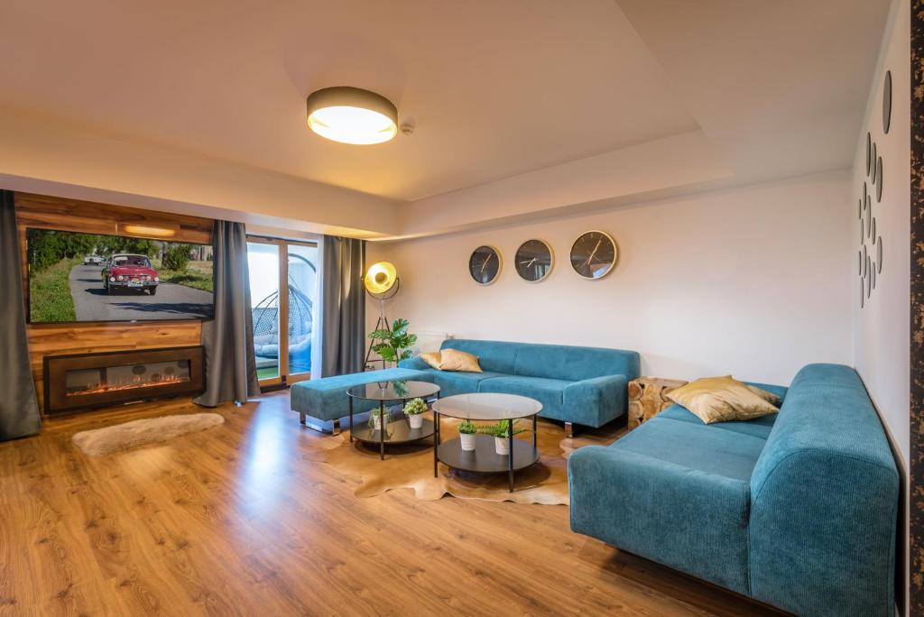 una sala de estar con sofás azules y una mesa. en Apartmanica Residence 606, en Donovaly