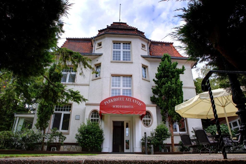 a building with a red awning in front of it at Parkhotel Atlantic in Heidelberg