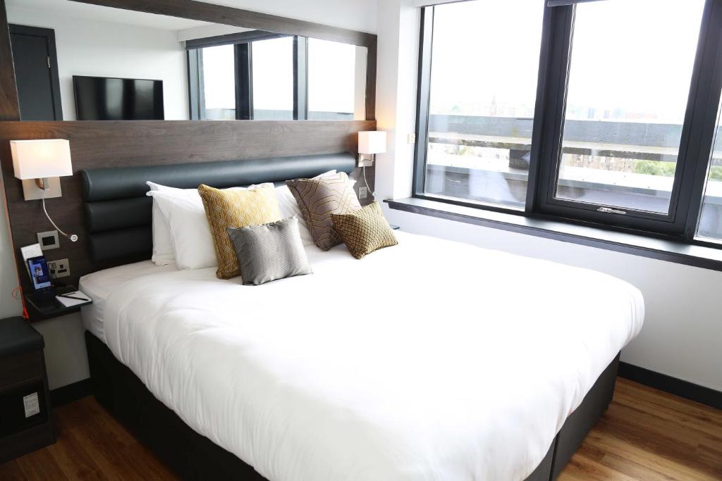 
a hotel room with a large bed and a large window at Haymarket Hub Hotel in Edinburgh
