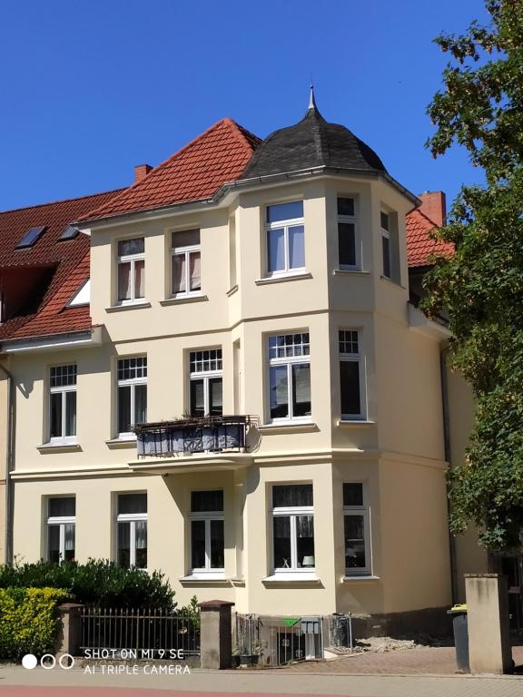 a large white building with a red roof at Apartment unterm Dach in Wismar