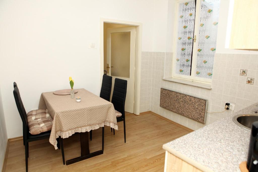a small kitchen with a table and chairs in a room at Apartma Grof in Koper