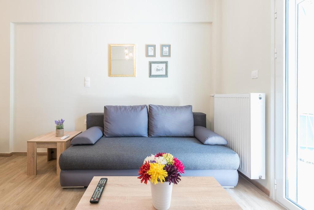 a living room with a couch and a vase with flowers at Exeptional Apartment in Athens