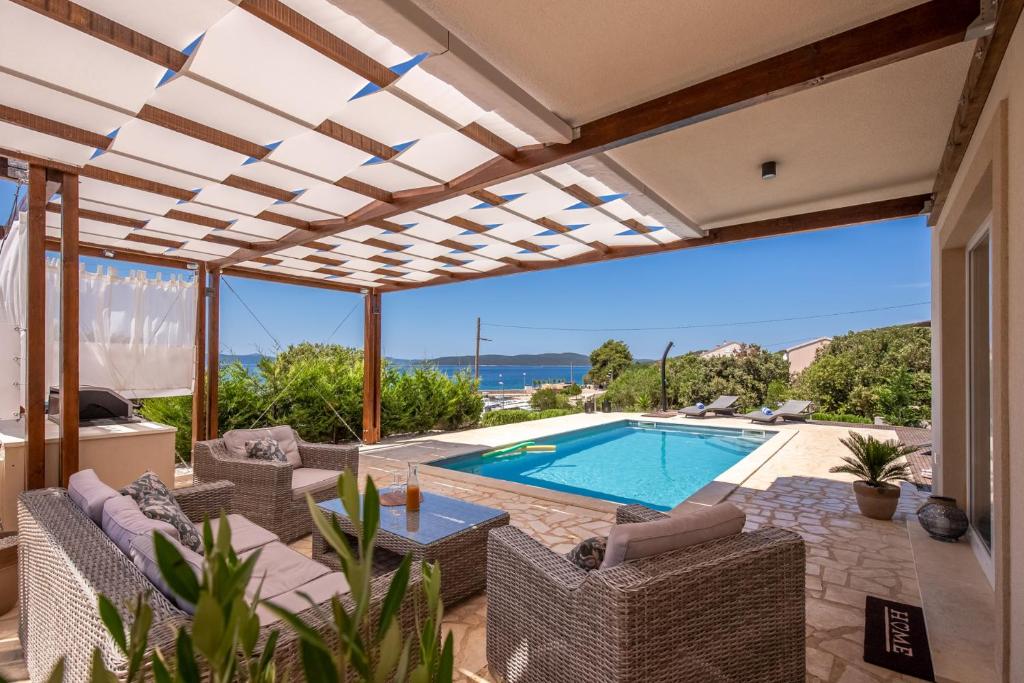 eine Villa mit einem Pool und einer Terrasse in der Unterkunft Villa Gellia in Ugljan