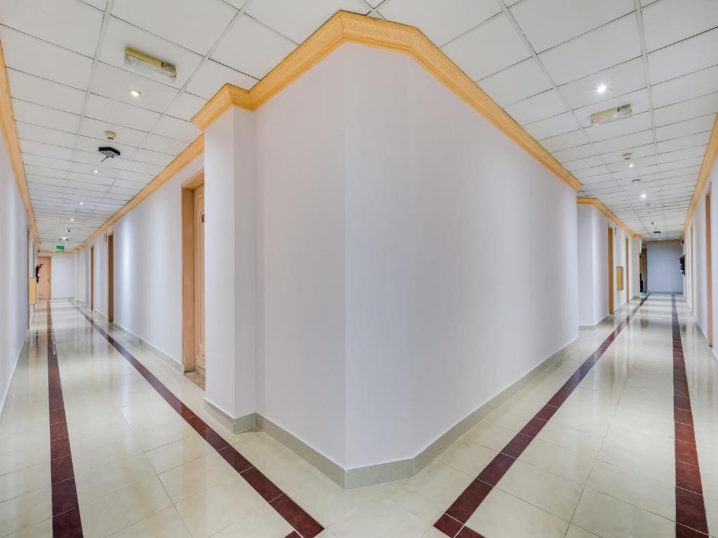 an empty hallway in a building with a large white wall at Al Rayan Hotel in Ajman 