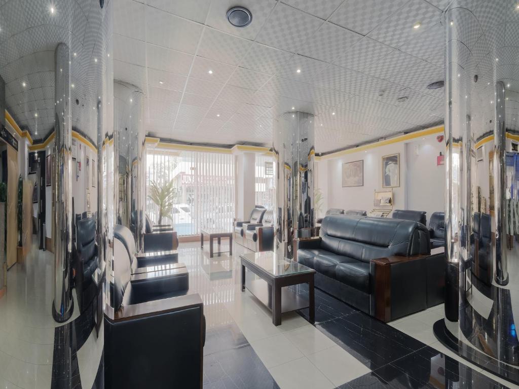 a waiting room with a leather couch and chairs at Al Rayan Hotel in Ajman 