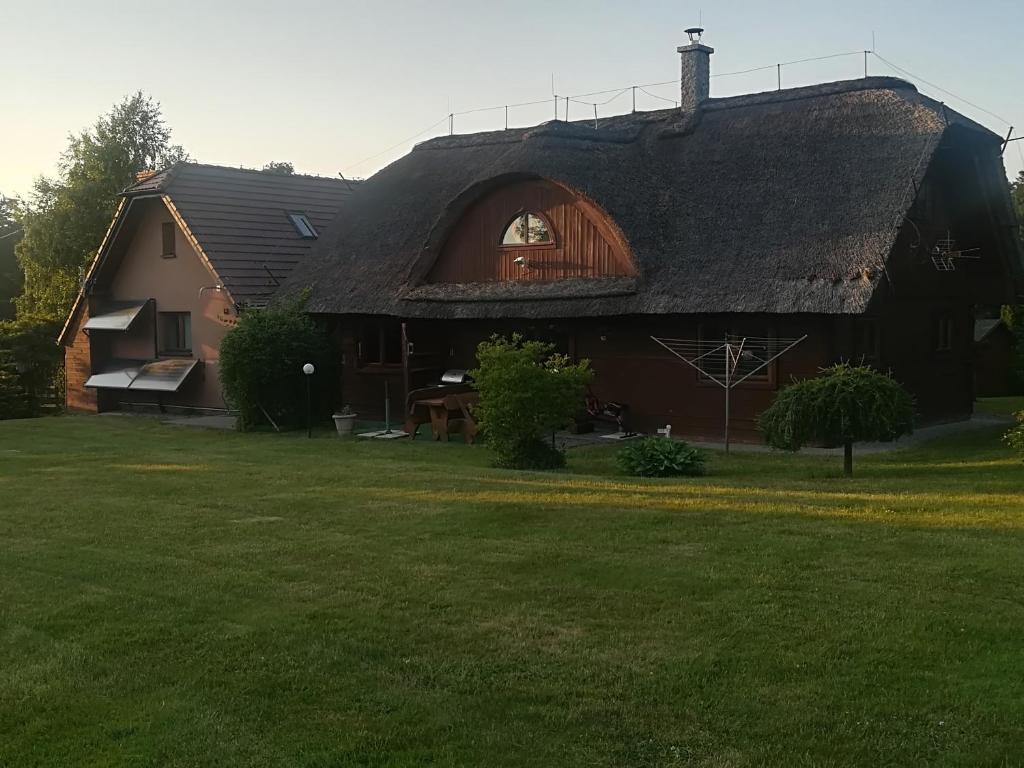 una casa grande con techo de paja en un patio en Agroturystyka Józefówka Borkowo Lęborskie, en Zwartowko 
