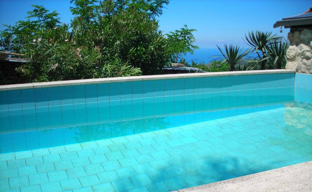 una piscina con piastrelle blu e alberi sullo sfondo di Casa Belle Vacanze a Spilinga