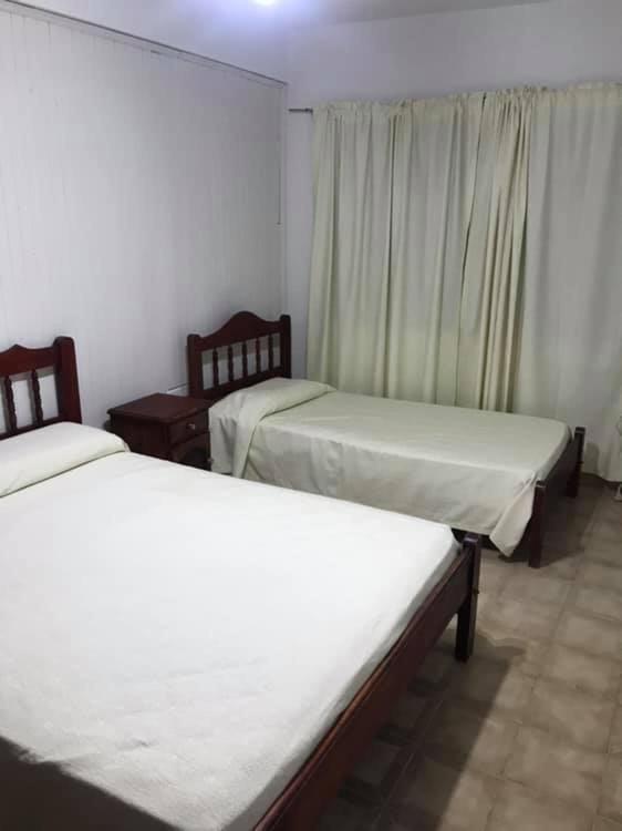 a room with two beds and a window at Cerro del sol, habitaciones privadas in Salta