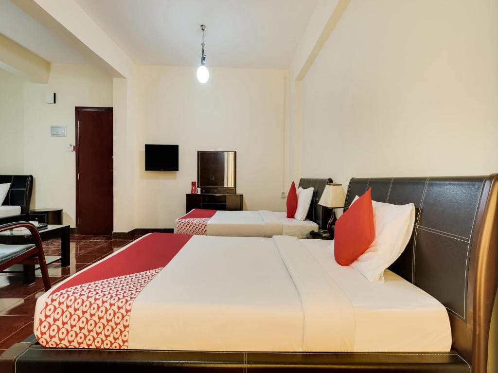 a hotel room with two beds and a television at Al Rayan Hotel in Ajman 