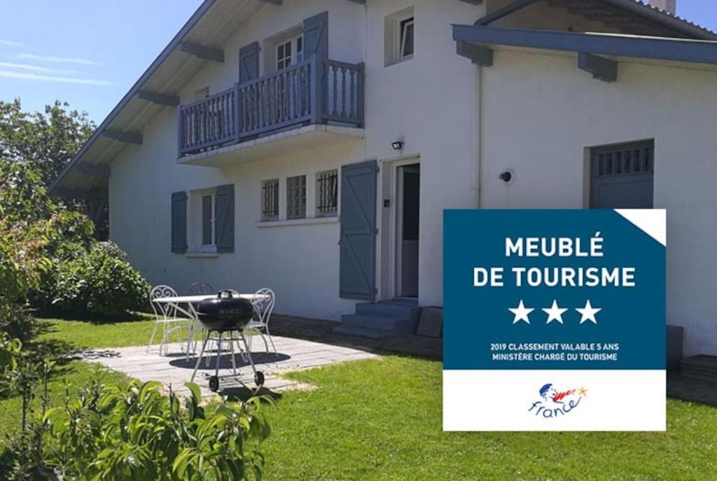 a sign in front of a house with a barbecue at Appartement de vacances avec jardin à Tarnos in Tarnos