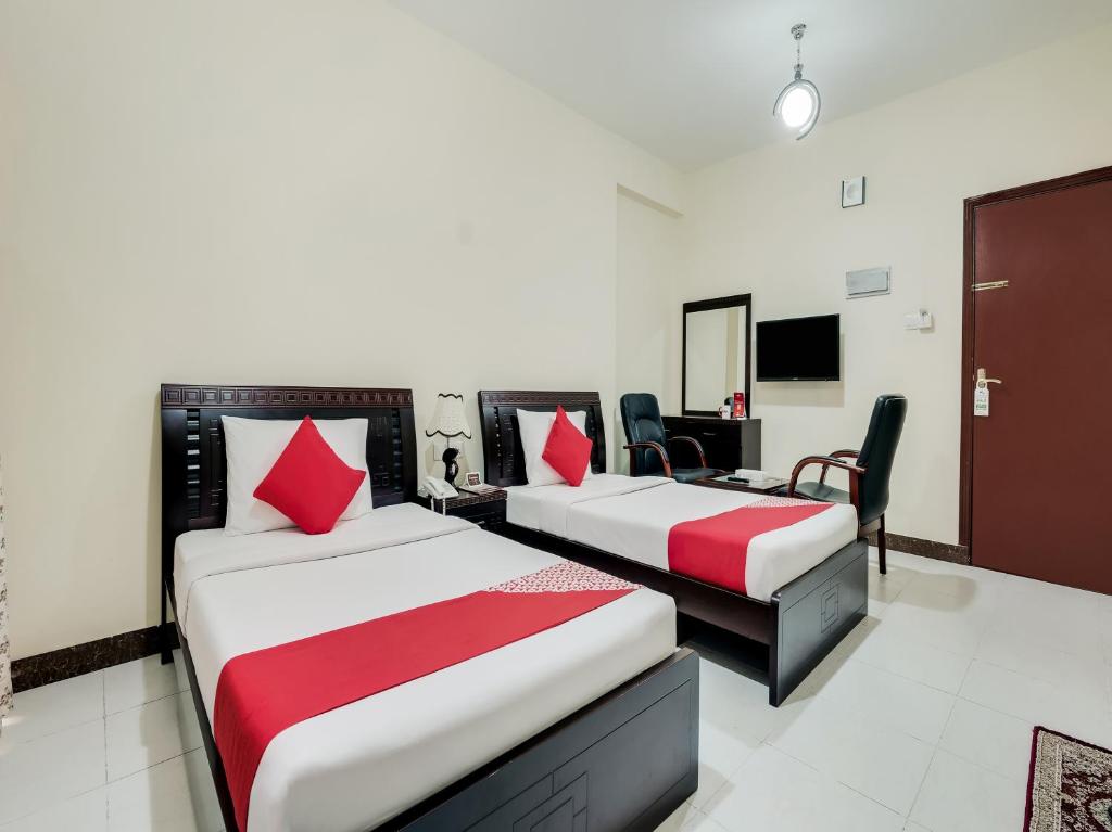 a hotel room with two beds and a tv at Al Rayan Hotel in Ajman 