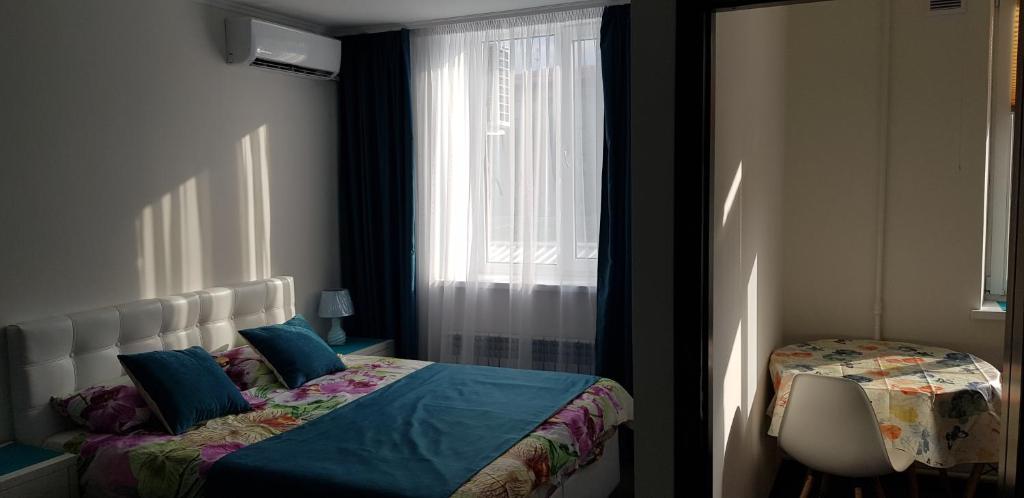 a bedroom with a bed with blue pillows and a window at Apartment in Balti in Bălţi