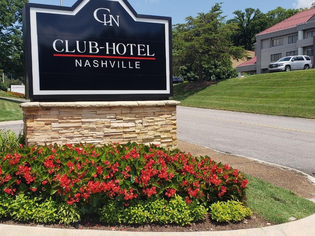 a sign for a club hotel with red flowers at Club Hotel Nashville Inn & Suites in Nashville